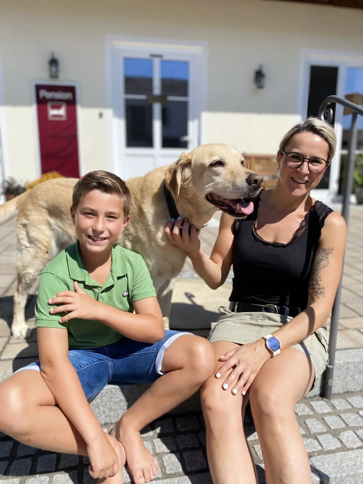 Susanne Gatzen mit Gästen und Hund vor der Pension